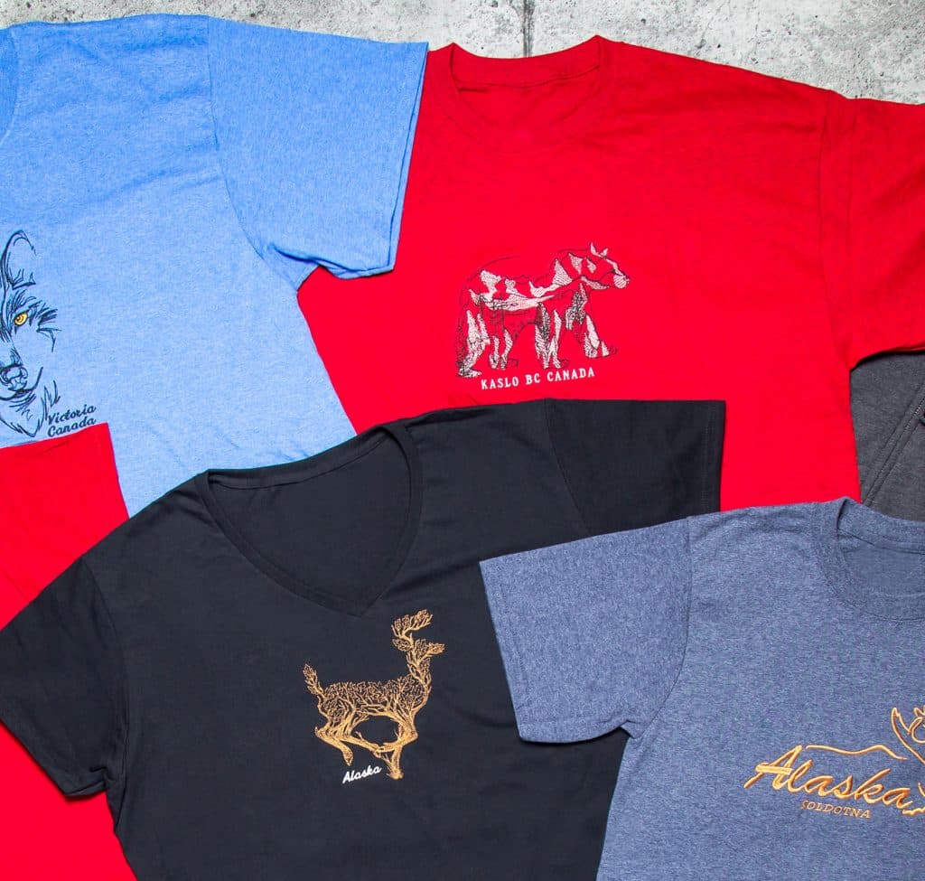 Close view of destination embroidery on a heather tee