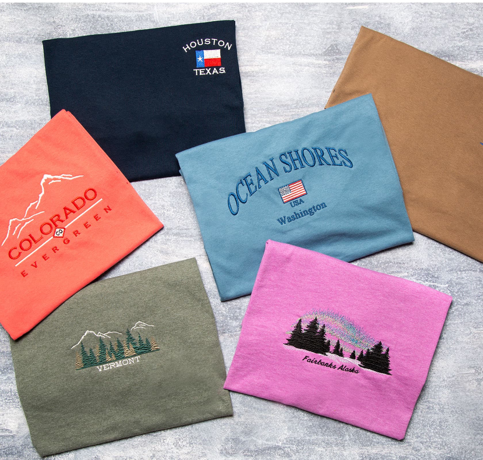 Embroidered souvenir tees folded on the flat display rack